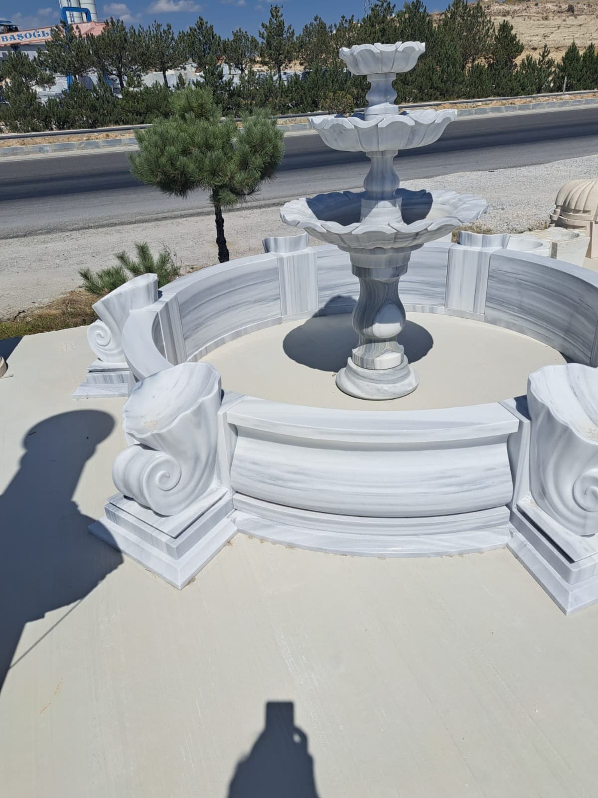 Marmorbrunnen mit mehreren Schalen und geschwungener Sitzbank